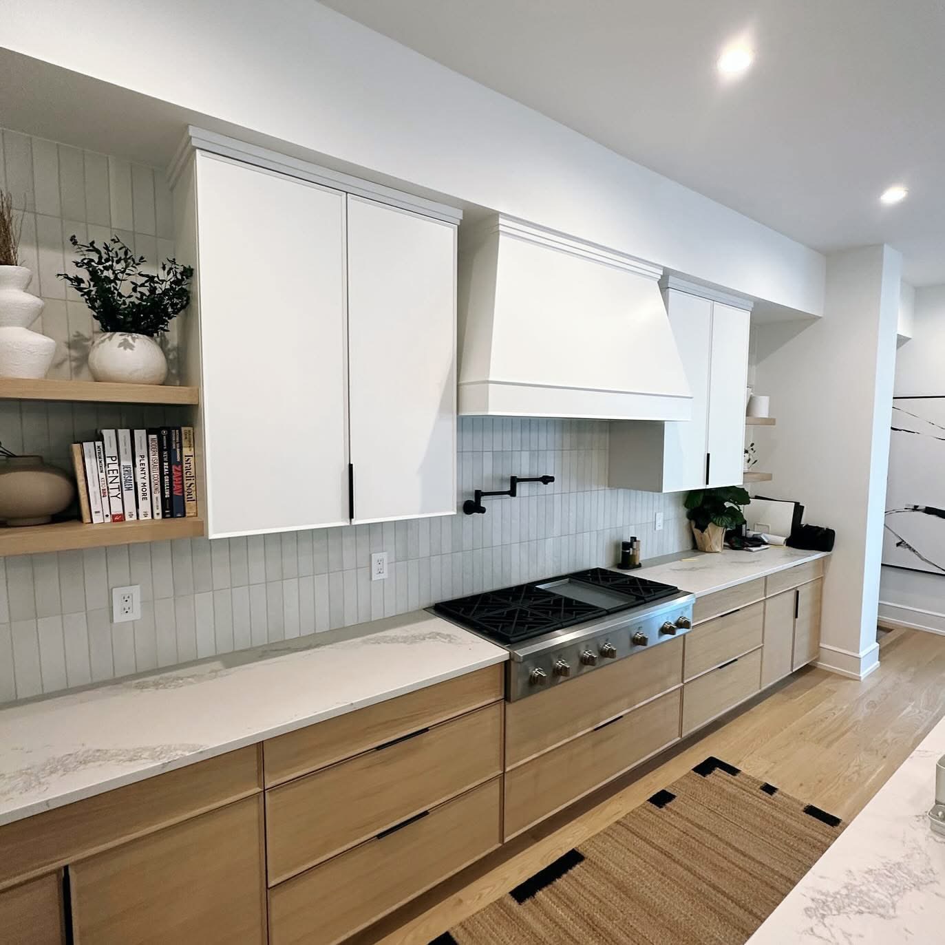 Modern kitchen with white oak cabinetry, quartz counters and black hardware